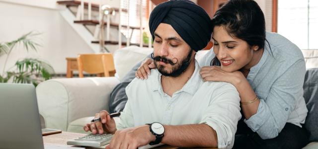 Happy couple looking at a calculator